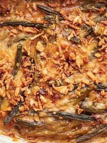 A white dish with green bean casserole in it.
