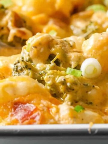 Loaded broccoli cauliflower casserole in a baking dish garnished with green onions.