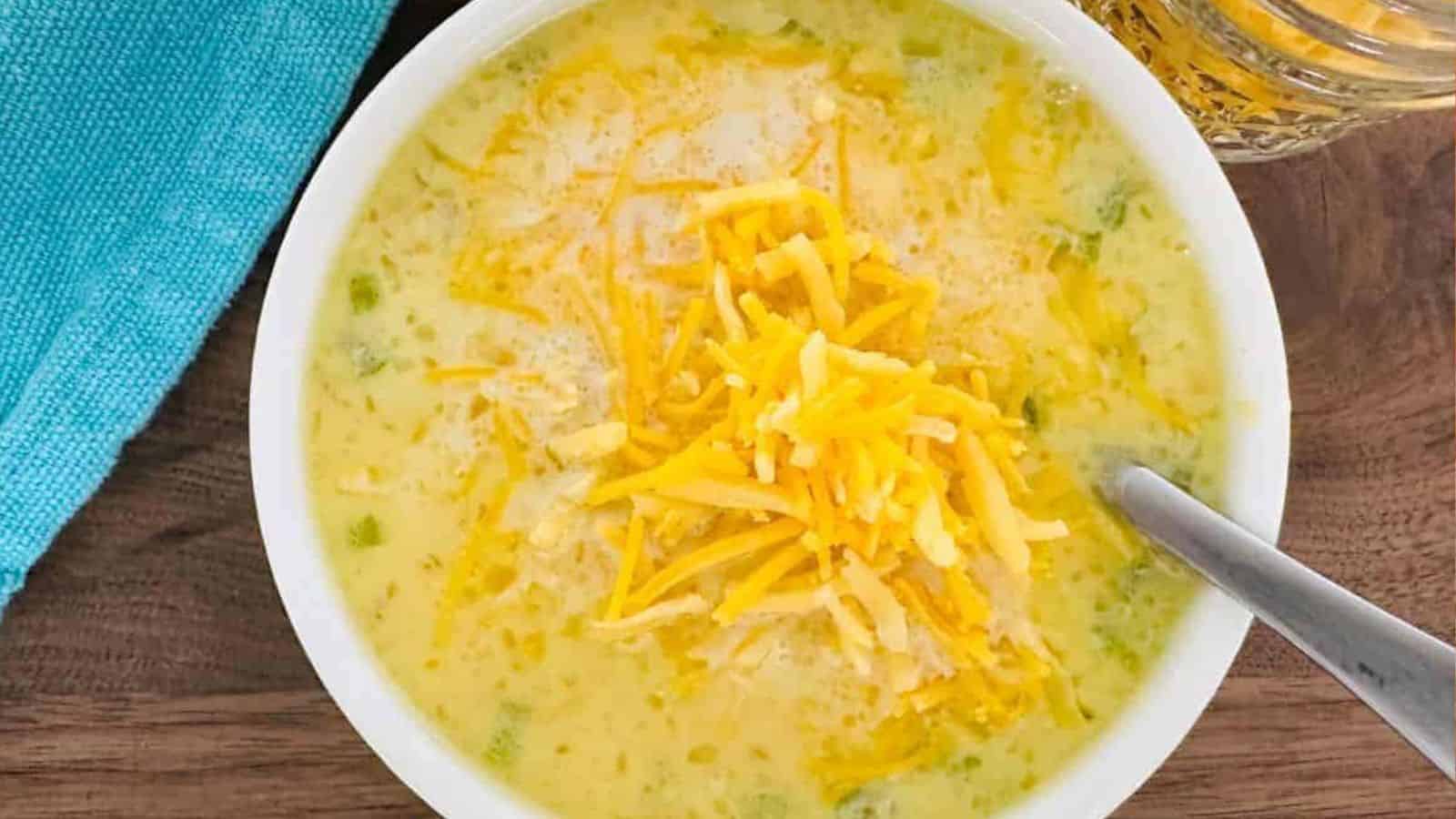 A bowl of soup with cheese and green peppers.