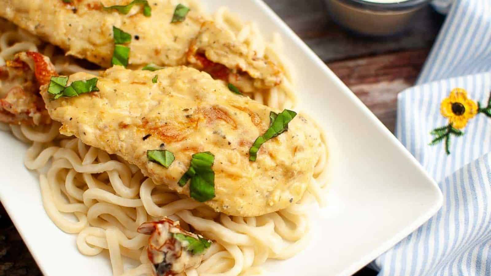 A plate of marry me chicken over pasta.