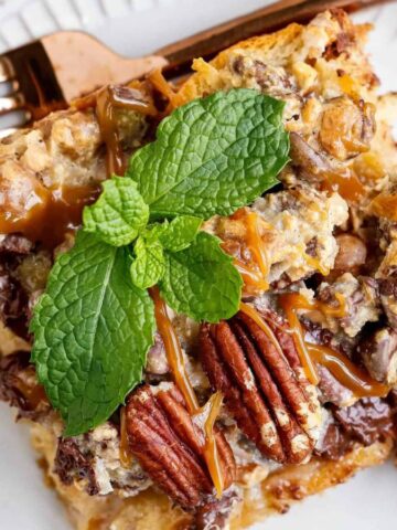 Flat lay of bread pudding topped with pecans and mint for garnish.