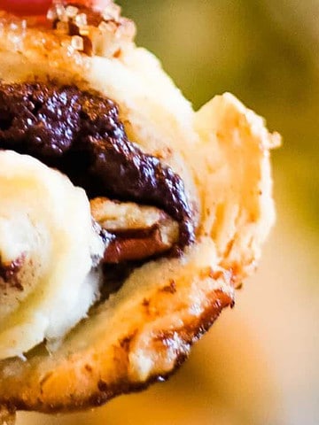 Low angle shot of rugelach cookies filled with chocolate and pecans.