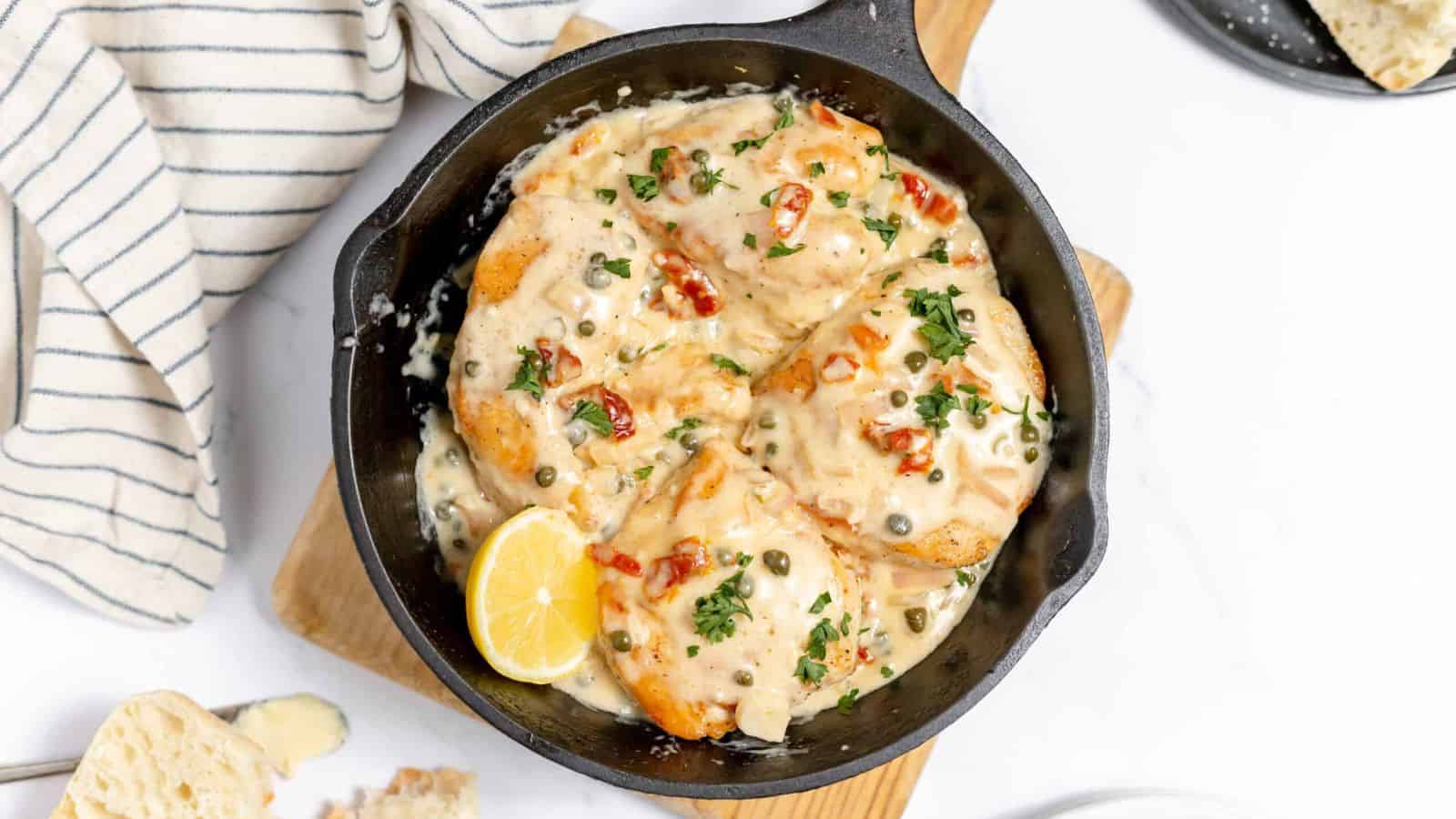 Creamy chicken in a cast iron skillet with capers.