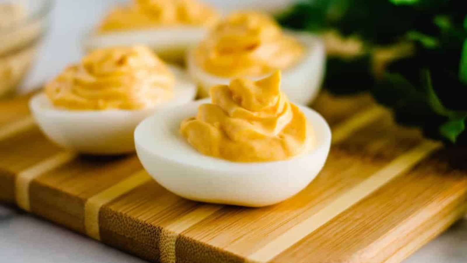 A batch of hummus deviled eggs on a serving board.