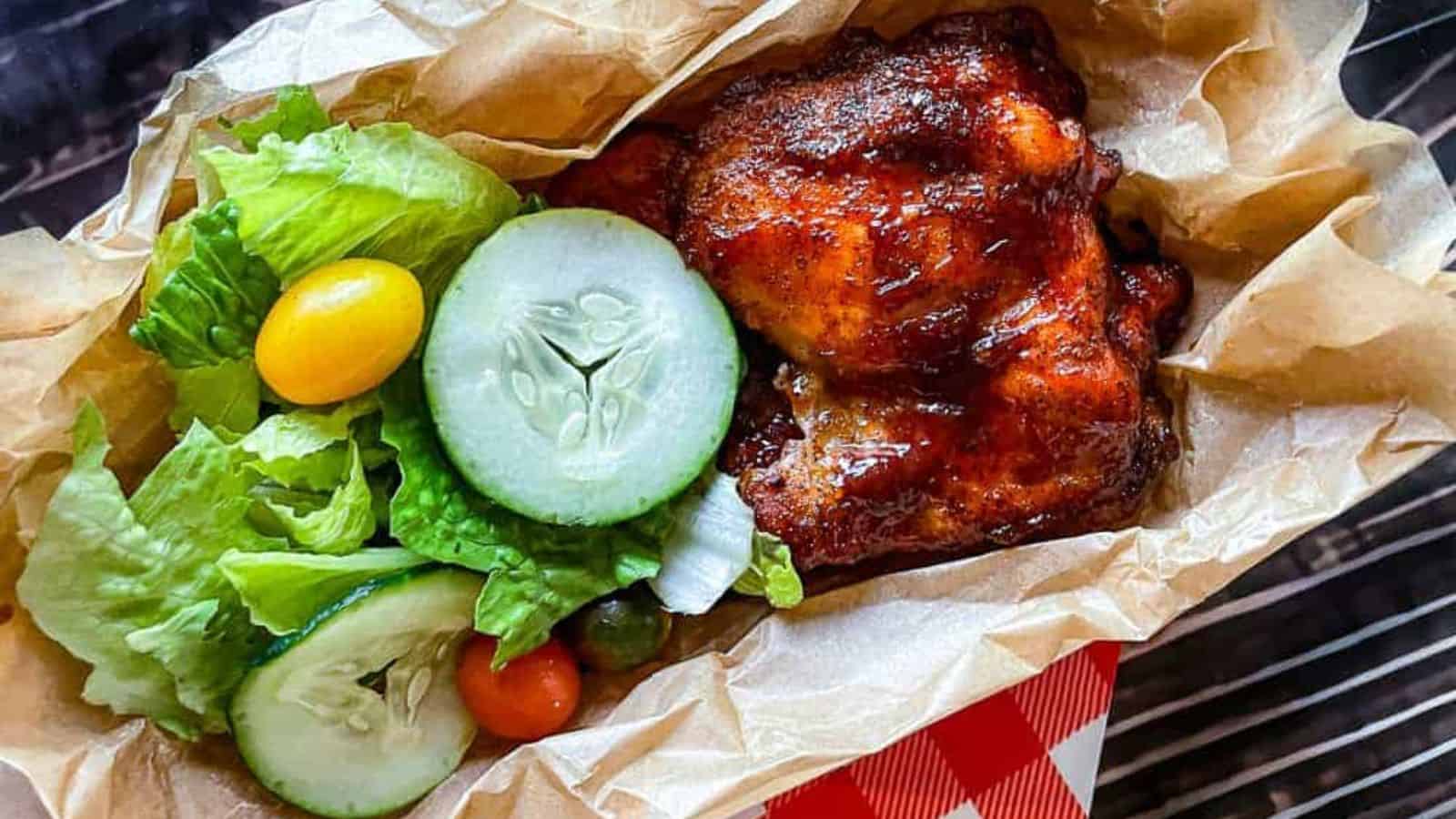 BBQ Chicken in a paper tray with a salad.