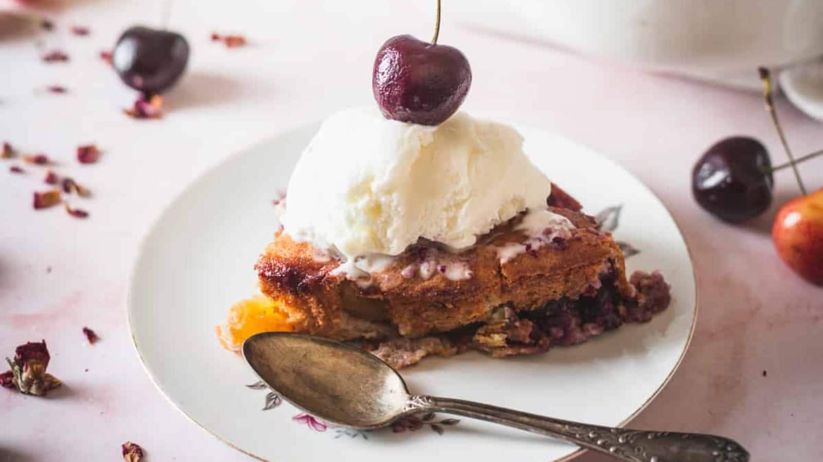 side view of slice of cherry cobbler with ice cream.