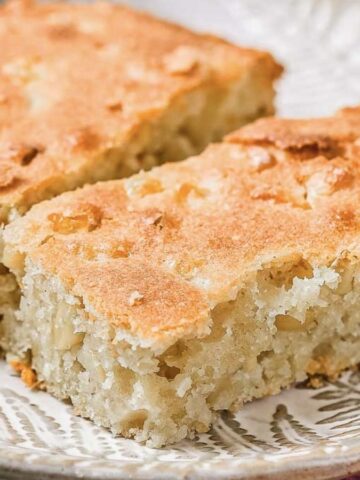 Two rectangular slices of light golden-brown cake with a slightly crumbly texture are placed side by side on a patterned plate.