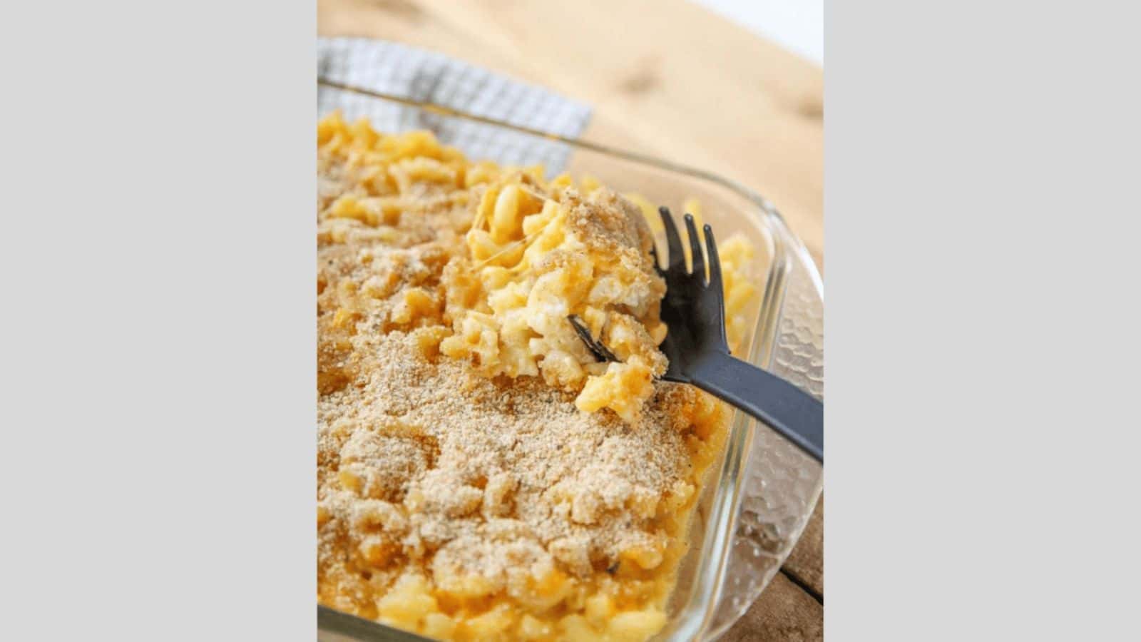 Baked macaroni and cheese topped with breakcrumbs in a casserole dish.