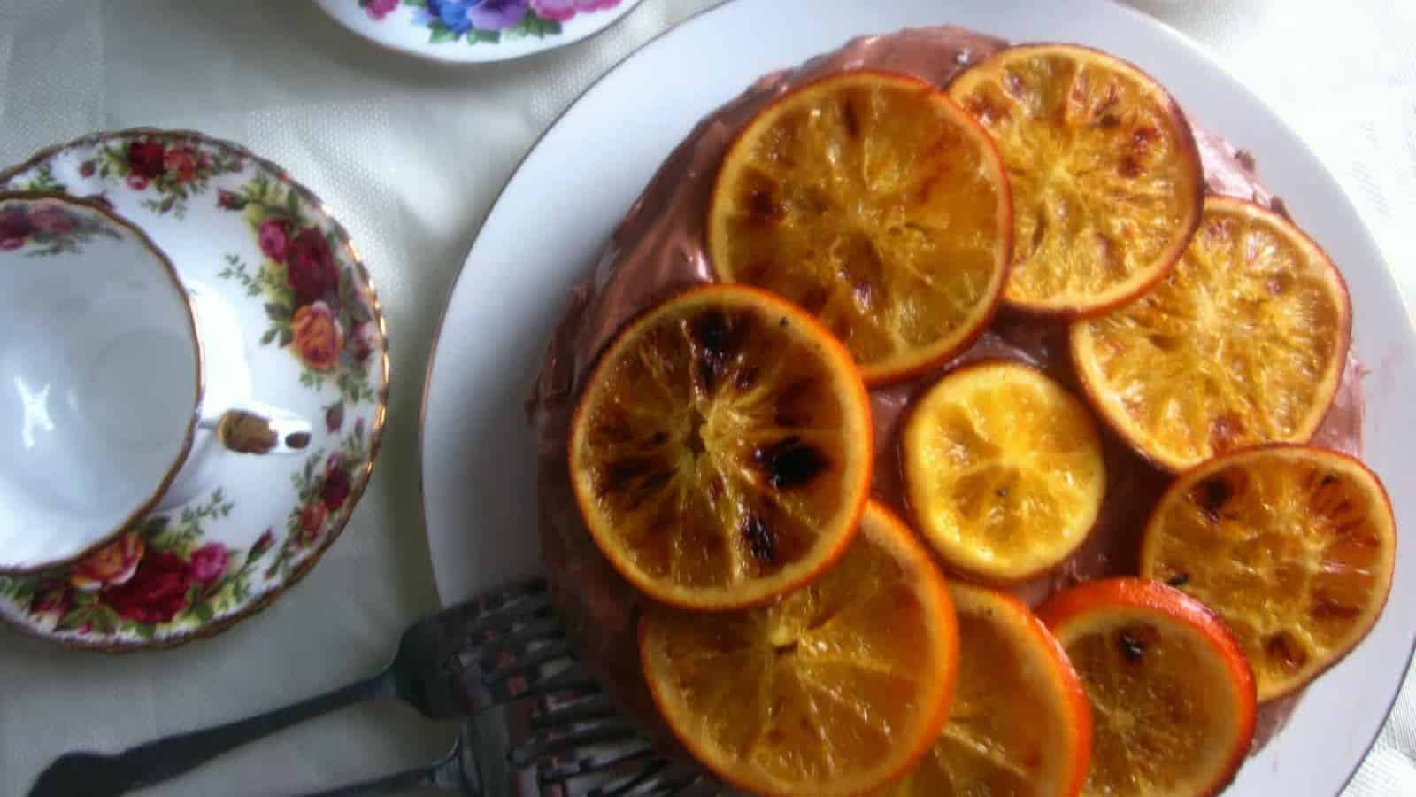 https://immigrantstable.com/wp-content/uploads/2024/06/Vegan-chocolate-orange-cake-with-chocolate-buttercream-frosting-and-candied-orange-slices.jpeg