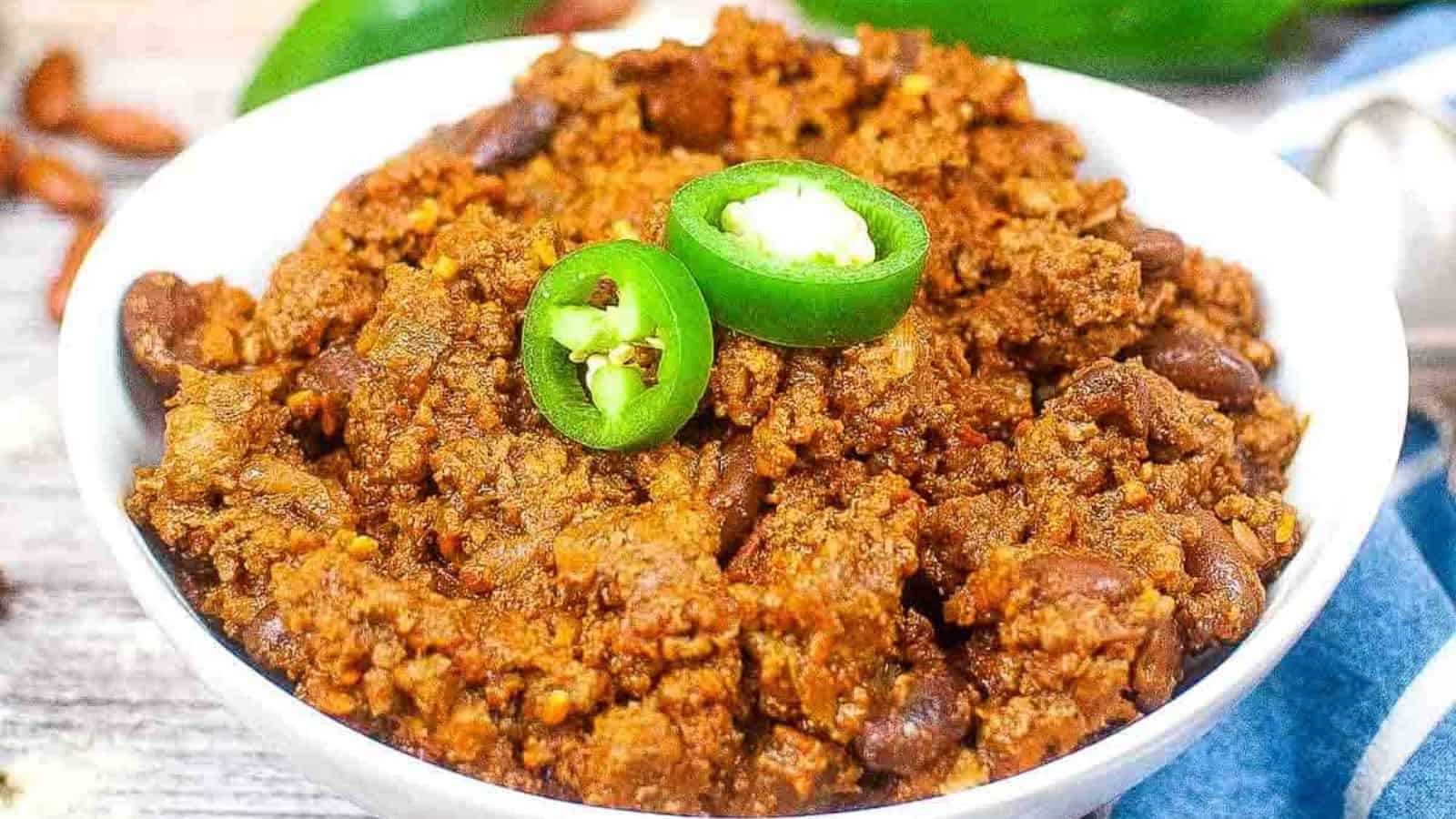 A bowl of Texas roadhouse chili with jalapenos and beans.