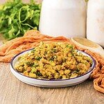 A plate of savory stuffing garnished with herbs sits on a wooden table, alongside jars and parsley, evoking the cozy comfort of slow cooker turkey pot pie.