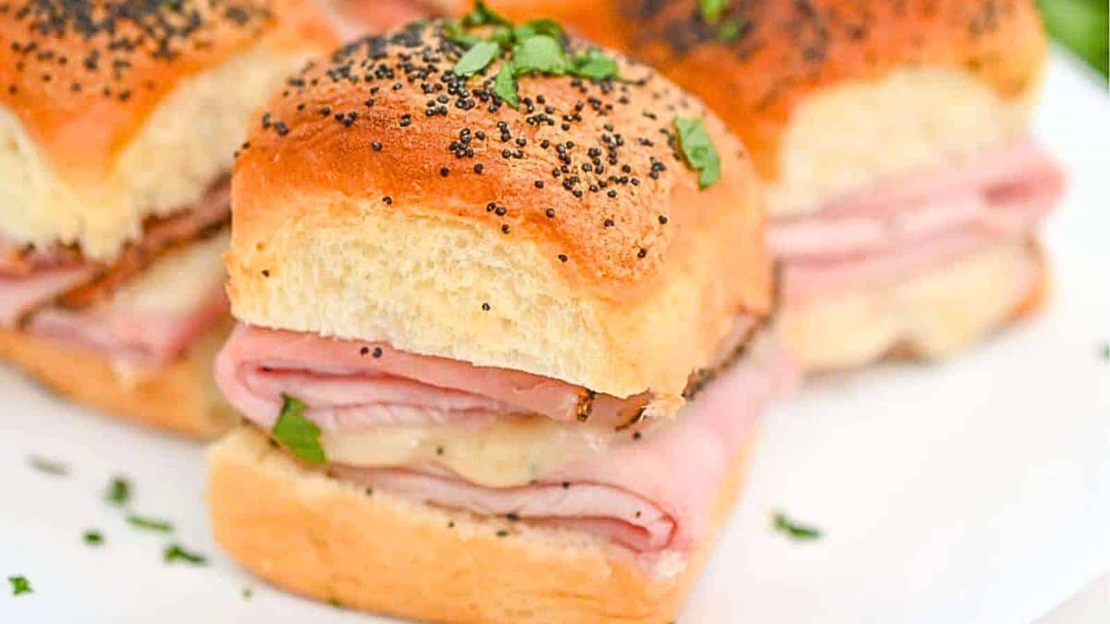 Ham and cheese sliders on a plate.