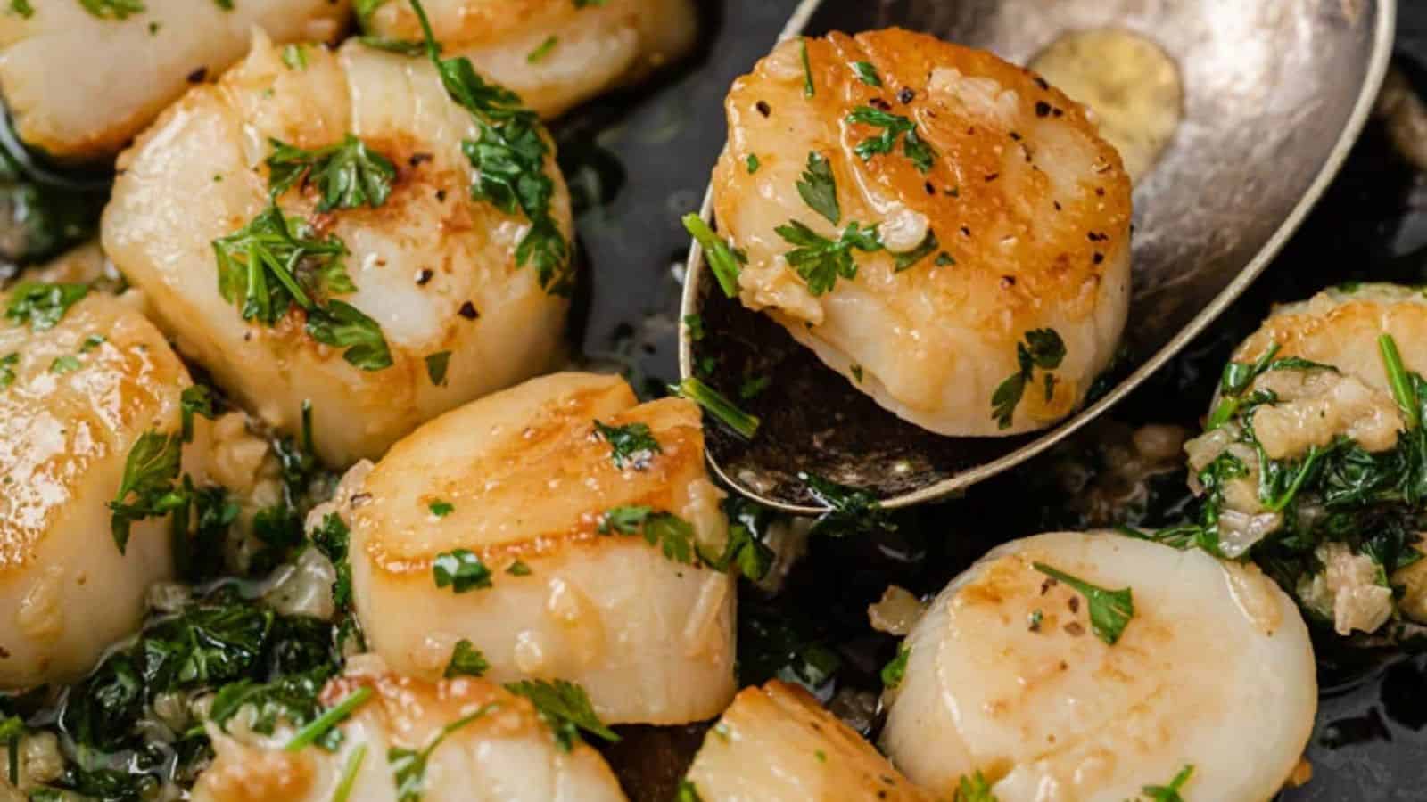 Scallops with parsley and garlic in a skillet.