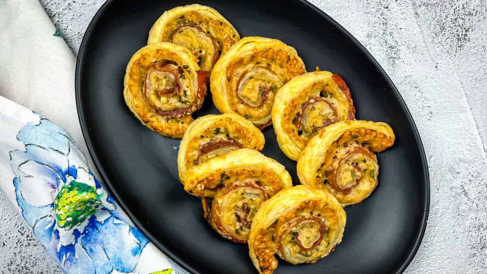 A plate of Prosciutto & Parmesan Puff Pastry pinwheels.