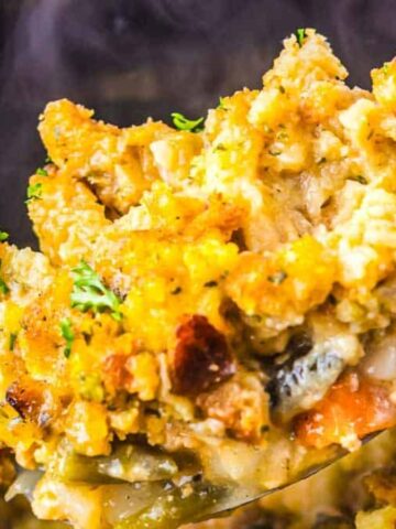 A spoonful of creamy chicken and stuffing casserole garnished with parsley.