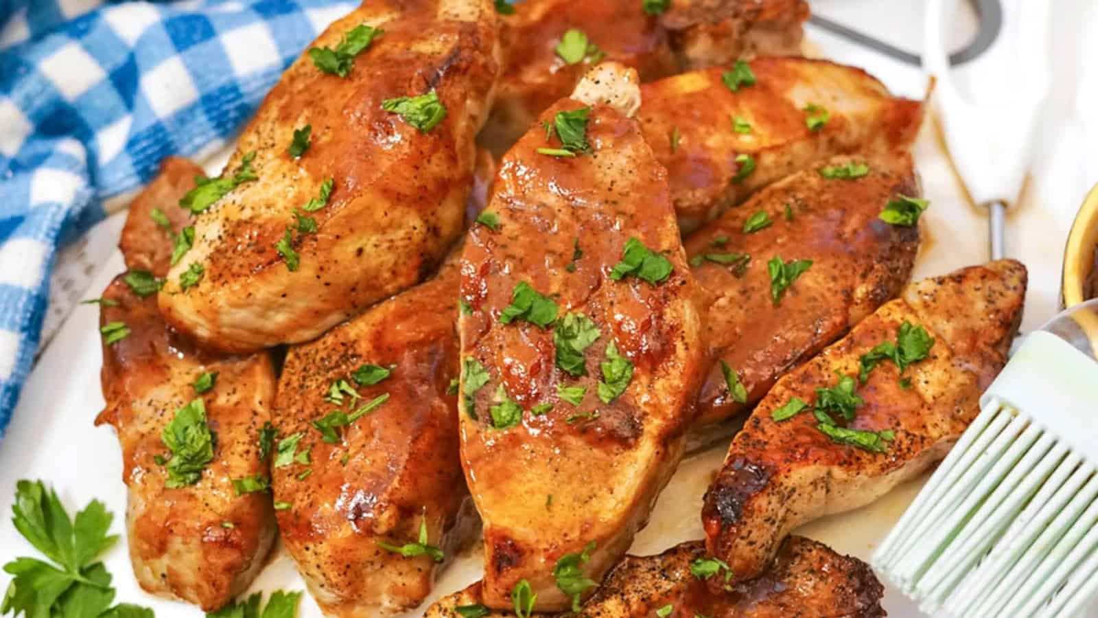A white plate with air-fried country style ribs, garnished with barbecue sauce and parsley.