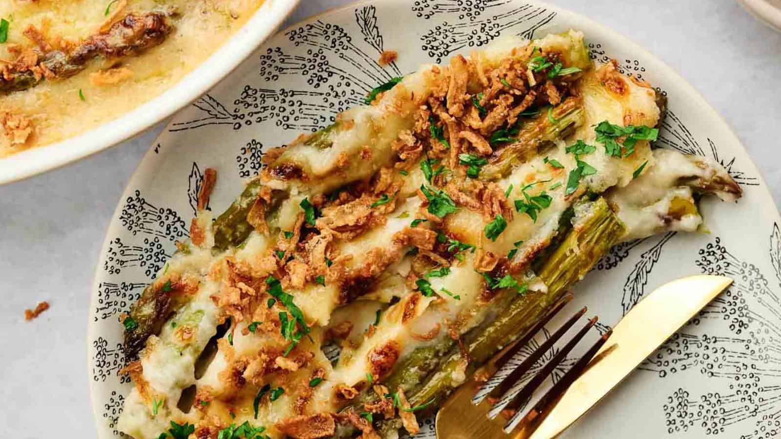 Cheesy asparagus casserole on a plate with a fork.