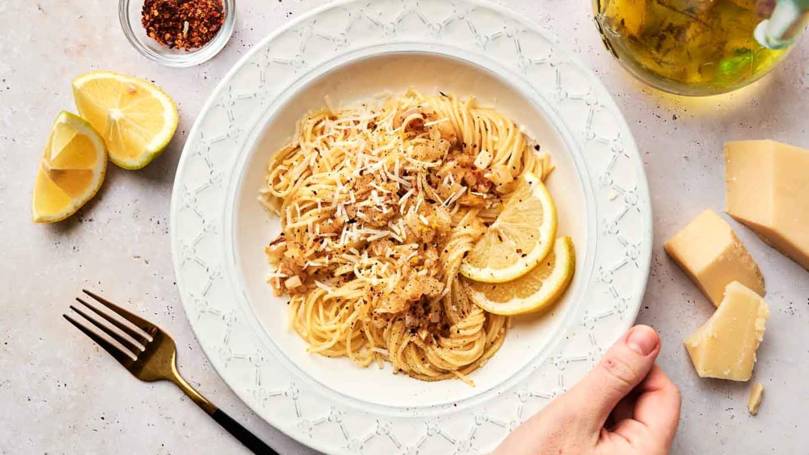 A bowl of pasta with lemon slices and parmesan cheese.