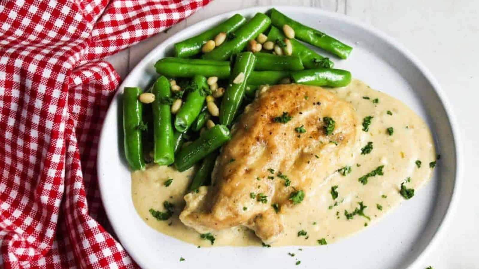 A plate with chicken and green beans on it.