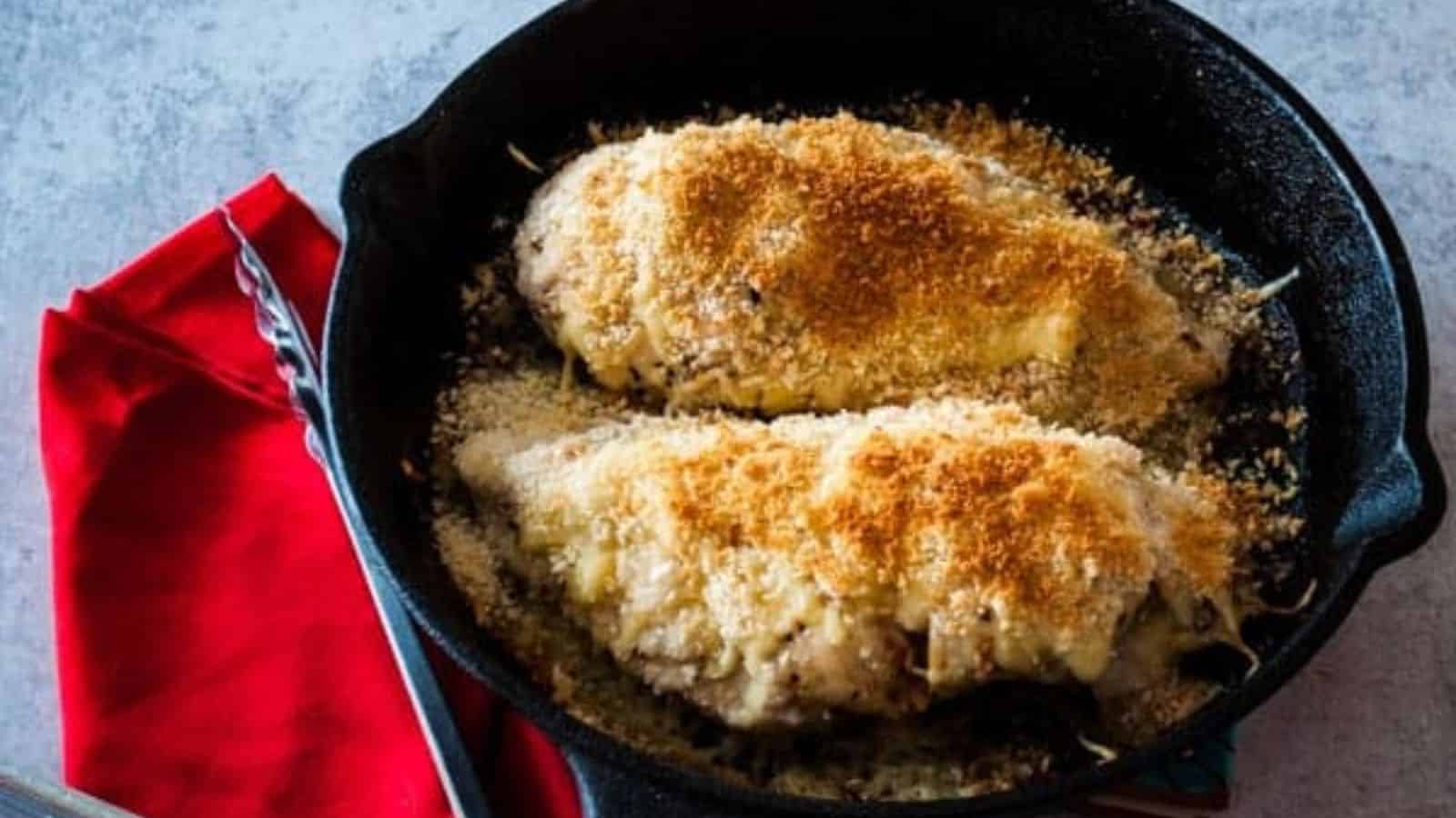 Two chicken cordon bleu in a skillet. 