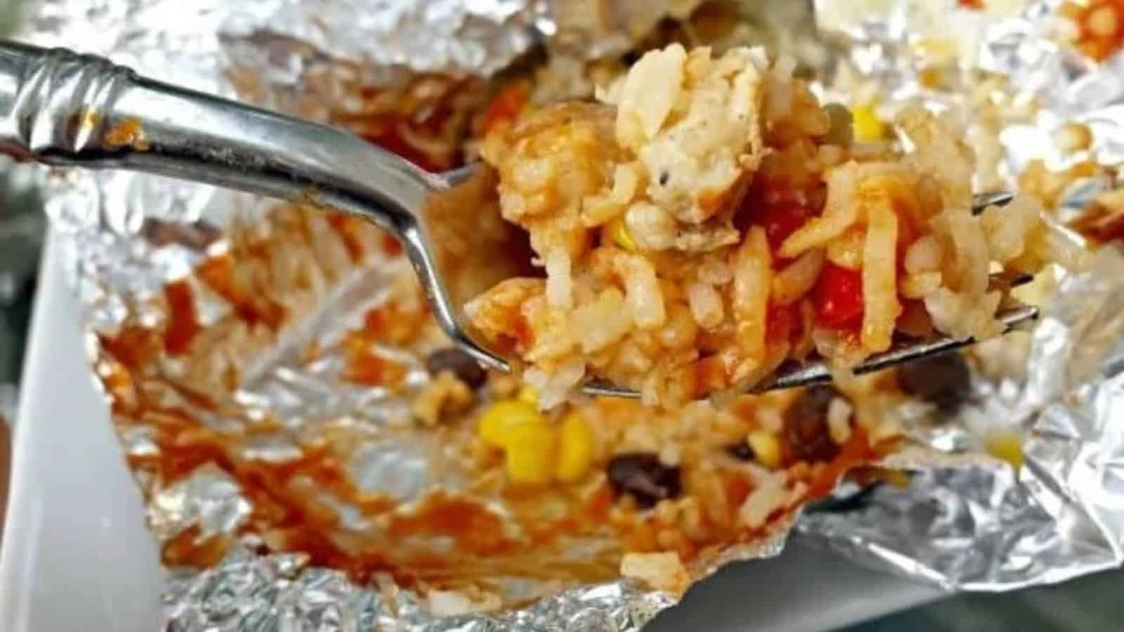 Grilled chicken foil packet with a fork holding a serving.
