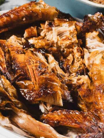 Roasted turkey pieces arranged on a white platter, ready to be served.