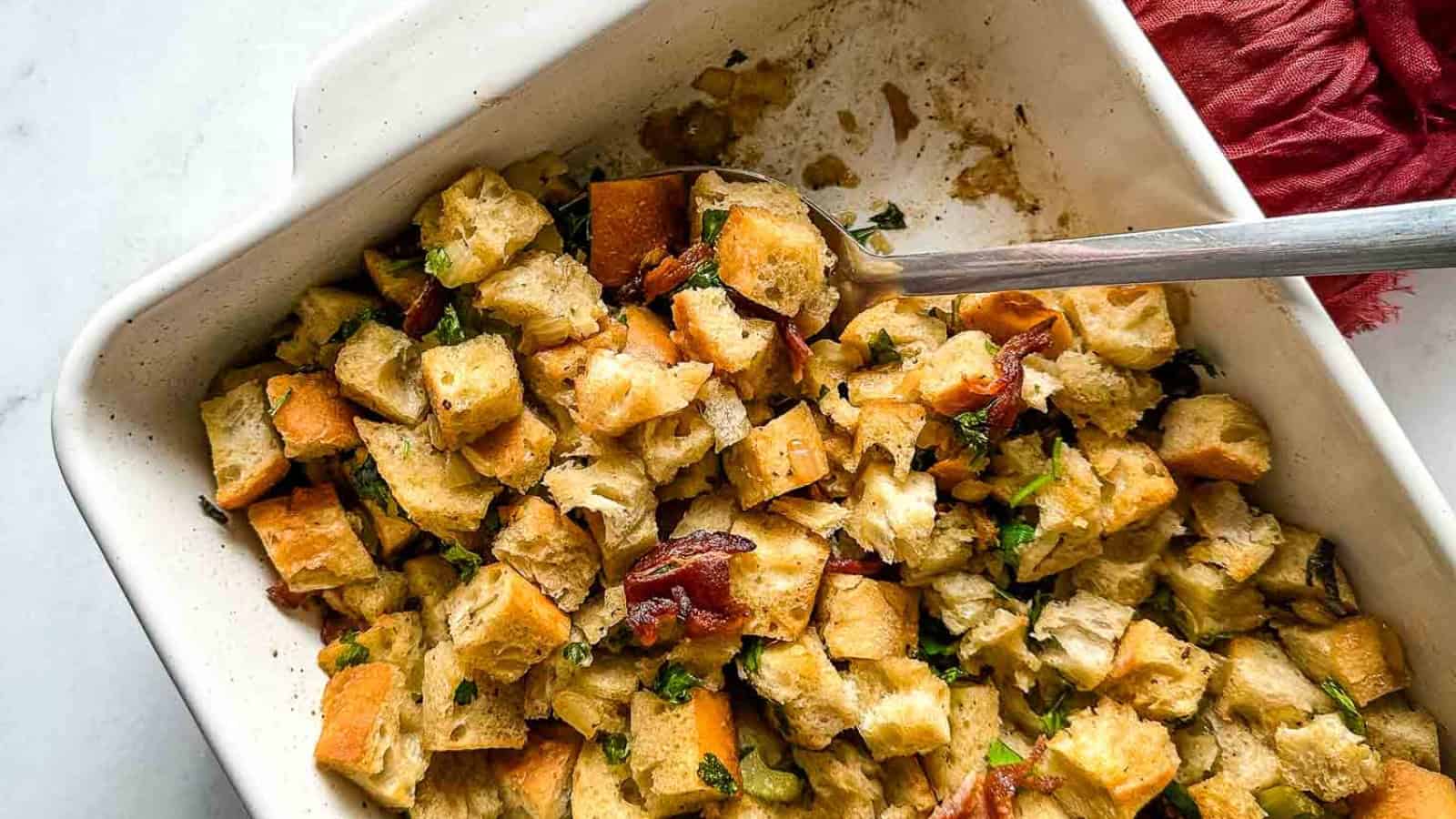 A closeup is shown of a baking dish full of bacon and sage stuffing.