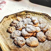 A plate of Funnel Cake Bites topped with powdered sugar and colorful sprinkles on a wooden tray—an easy air fryer recipe perfect for sharing.