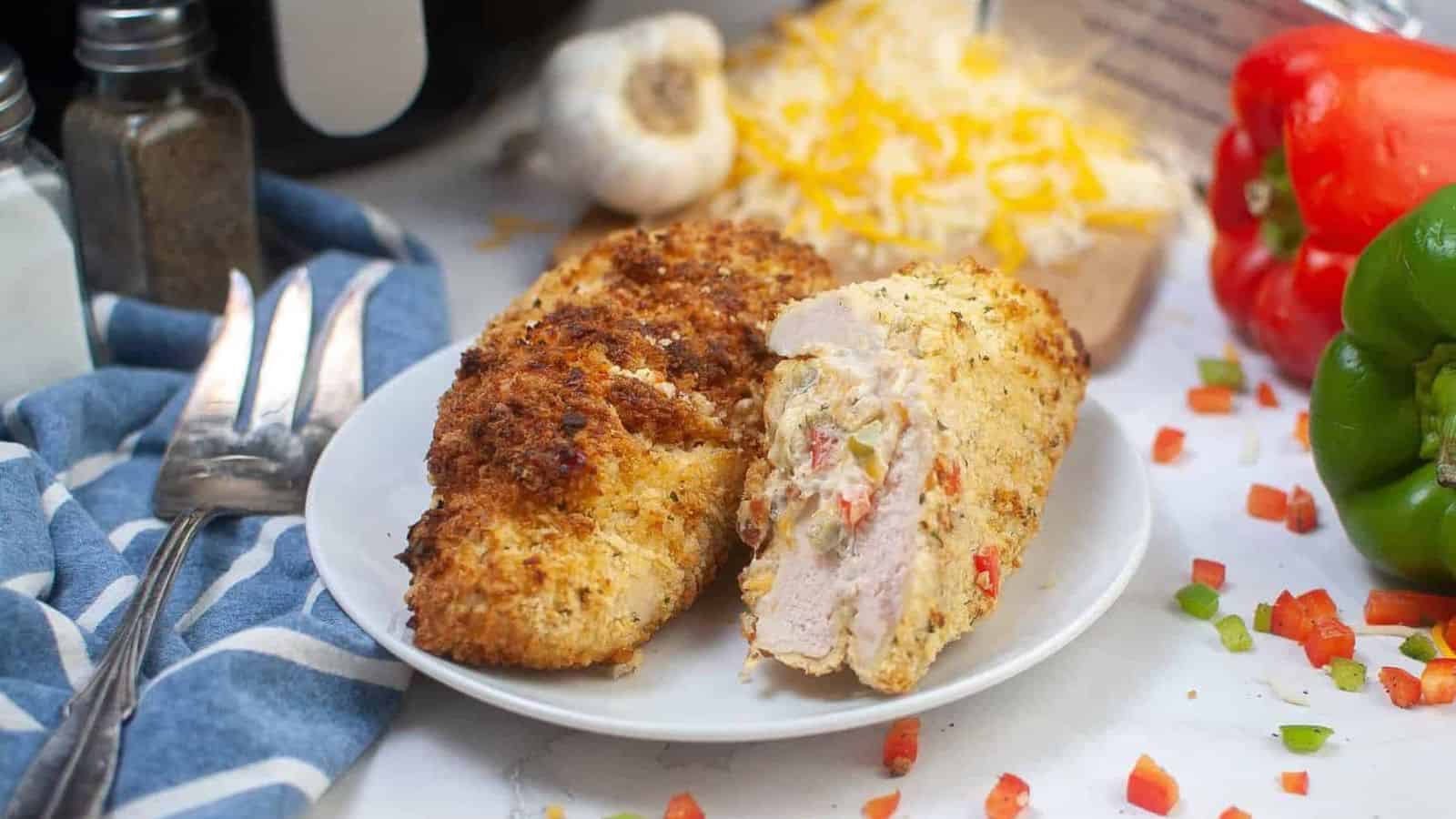 Chicken breasts on a plate with vegetables around it.