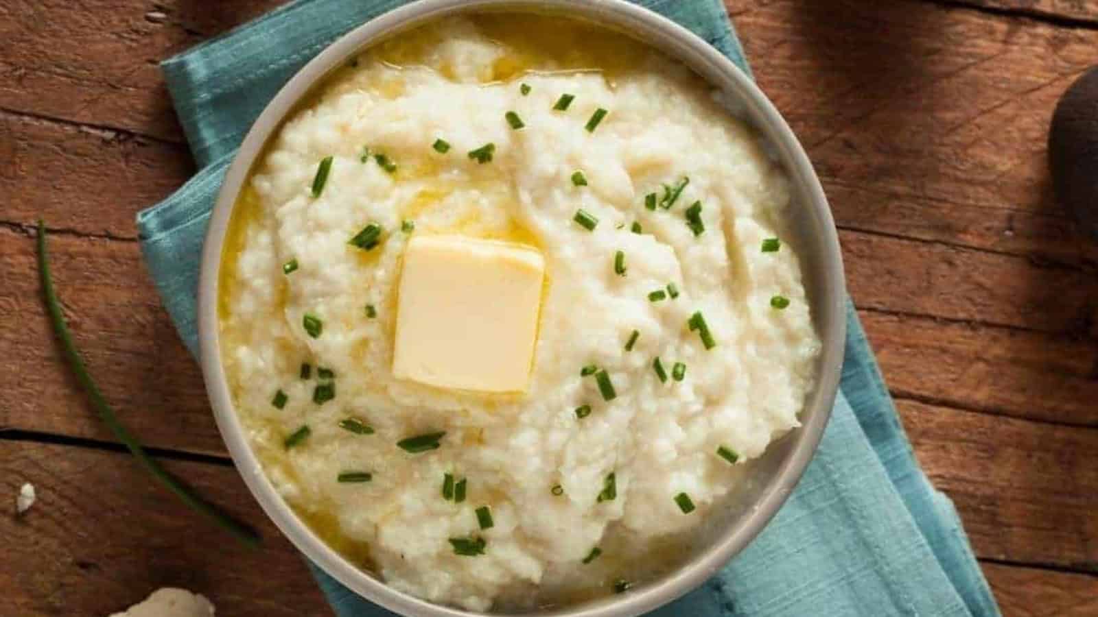 Mashed cauliflower potatoes with butter on top in a bowl.