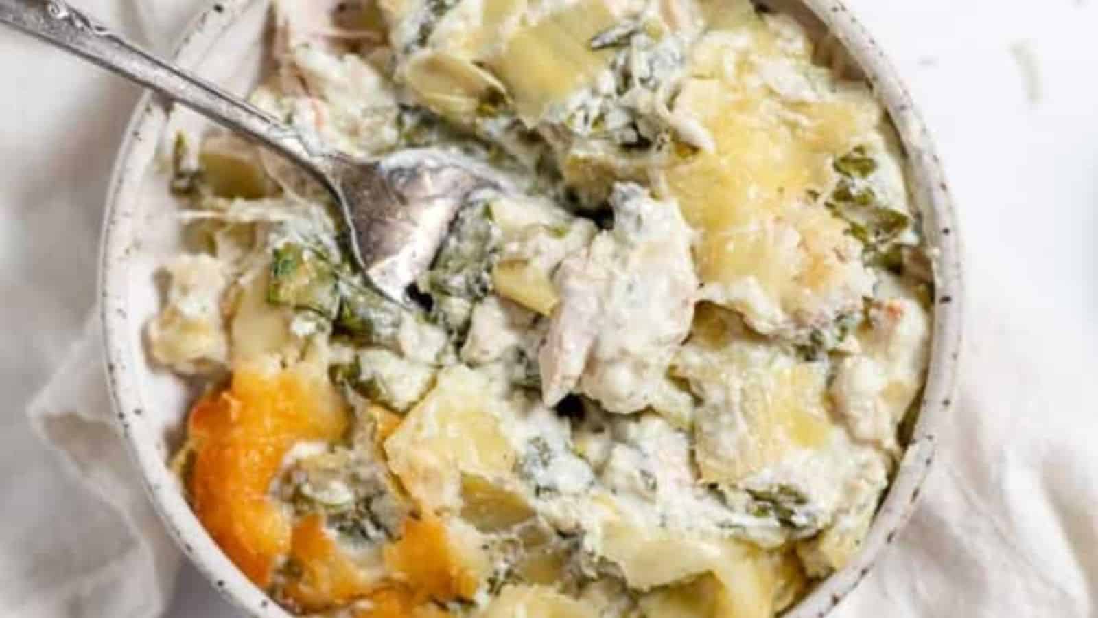 A spoon in a cheesy casserole. 