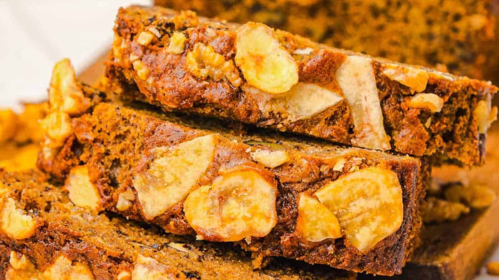 Close-up of sliced banana bread topped with walnuts and banana chips.