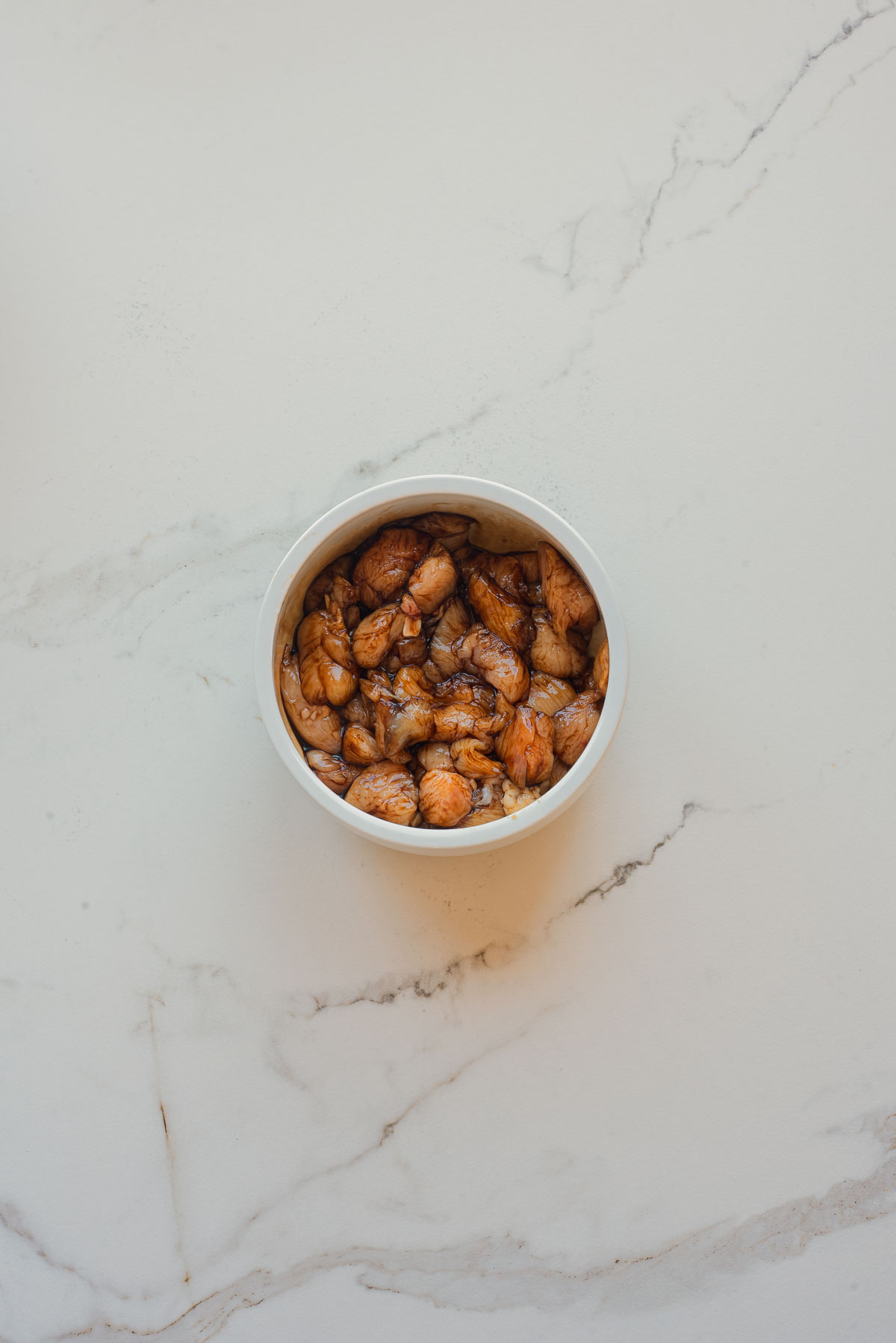 A white bowl filled with sea urchin (uni) sits on a light marble surface, ready to inspire your next chicken recipe or complement salt and pepper chicken fresh from the air fryer.