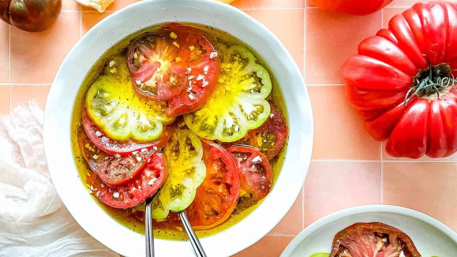 Closeup of marinated heirloom tomatoes in a yellow and white pie dish.