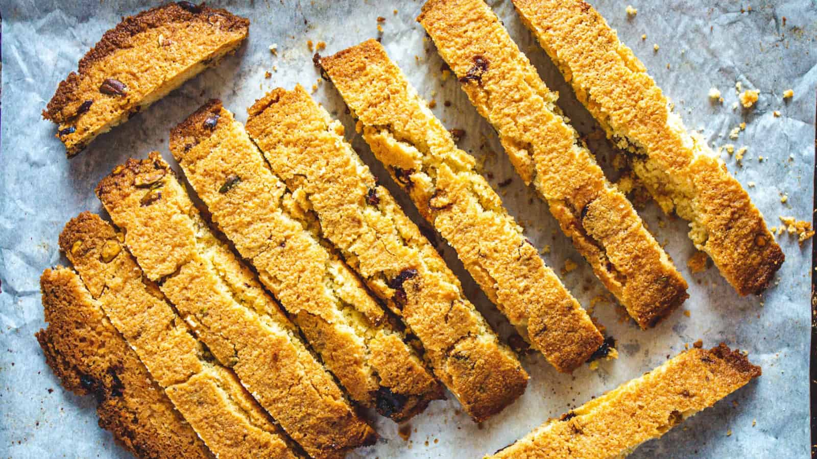 Golden brown biscotti slices with chocolate chips on parchment paper.