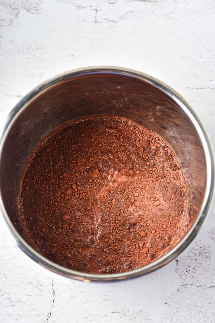 Powdered cocoa and flour mixture in a large metal mixing bowl on a light countertop, perfect for making Peppermint Hot Chocolate or your favorite Hot Chocolate recipe.