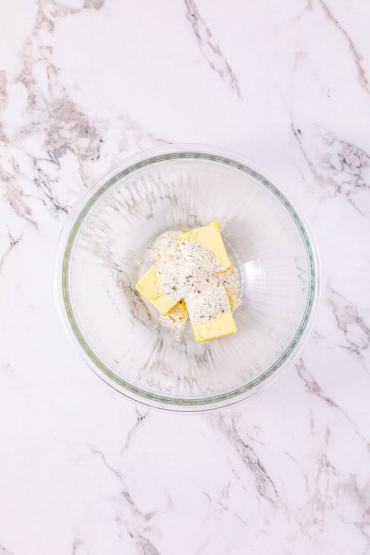 Glass bowl with butter and flour inside, placed on a white marble countertop&mdash;perfect for starting your Easy Chicken Sliders or prepping Buffalo Chicken Slider ingredients.