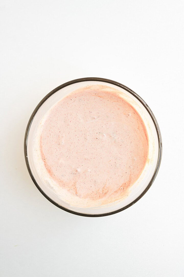 Glass bowl filled with light pink chipotle sauce on a white background, viewed from above&mdash;the perfect topping for fajita bowls or shrimp fajita bowls.