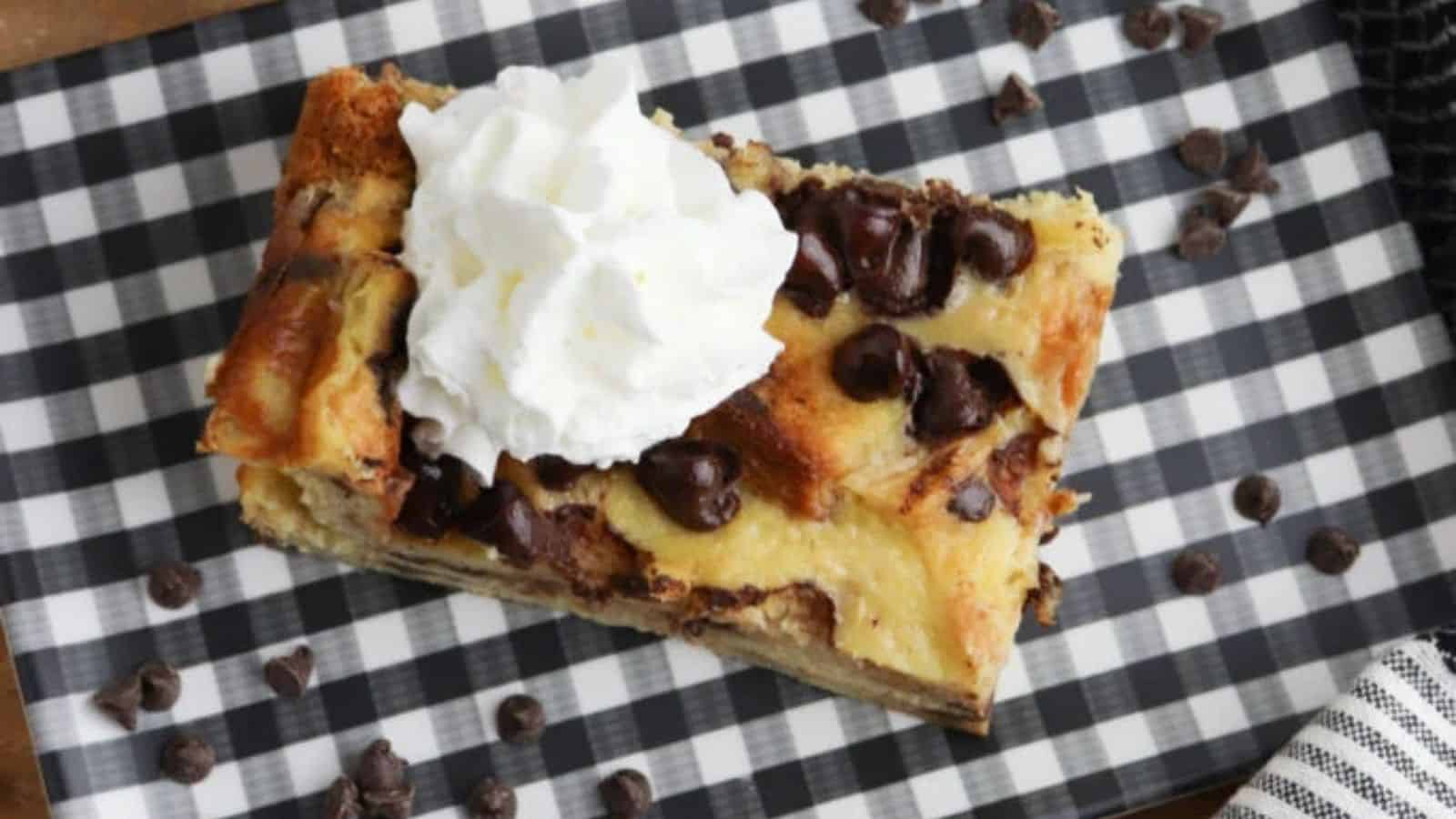 A black and white plate with a piece of french toast casserole on top.