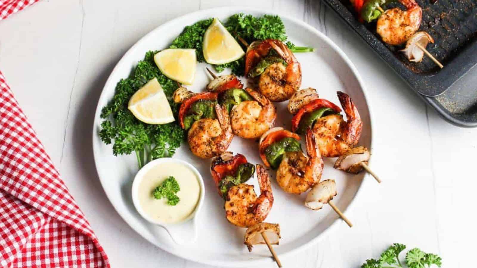 Shrimp skewers on a plate with lemon wedges.