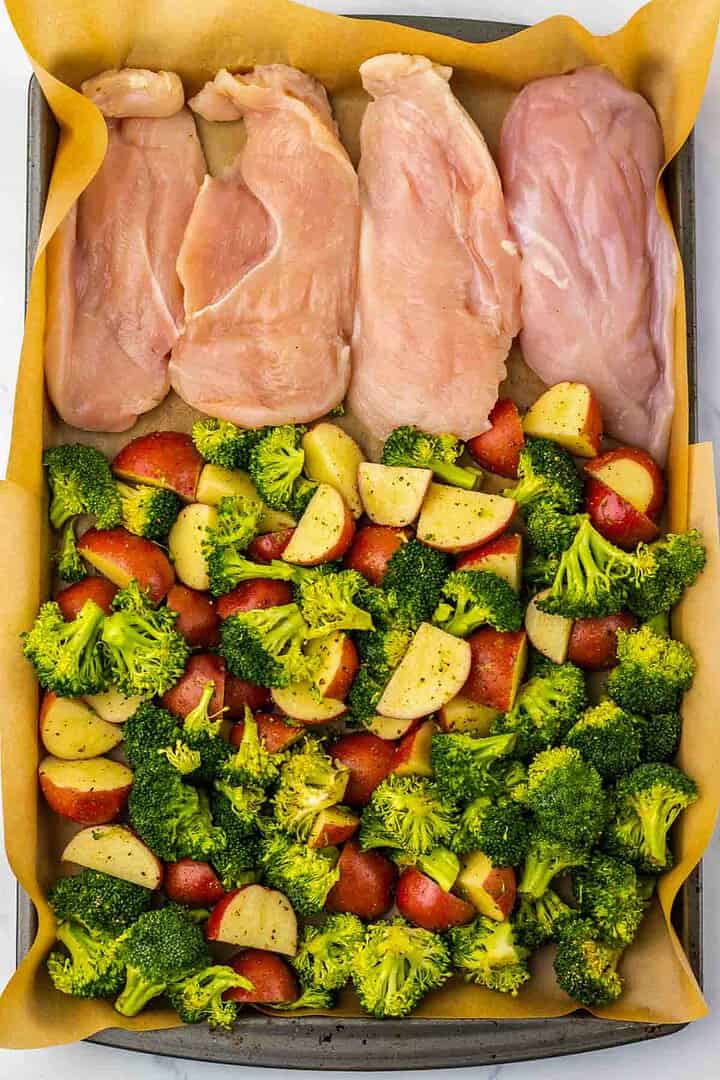 Enjoy a delicious Parmesan Chicken and seasoned broccoli with red potatoes, all arranged on a parchment-lined sheet pan for the perfect Sheet Pan Dinner.