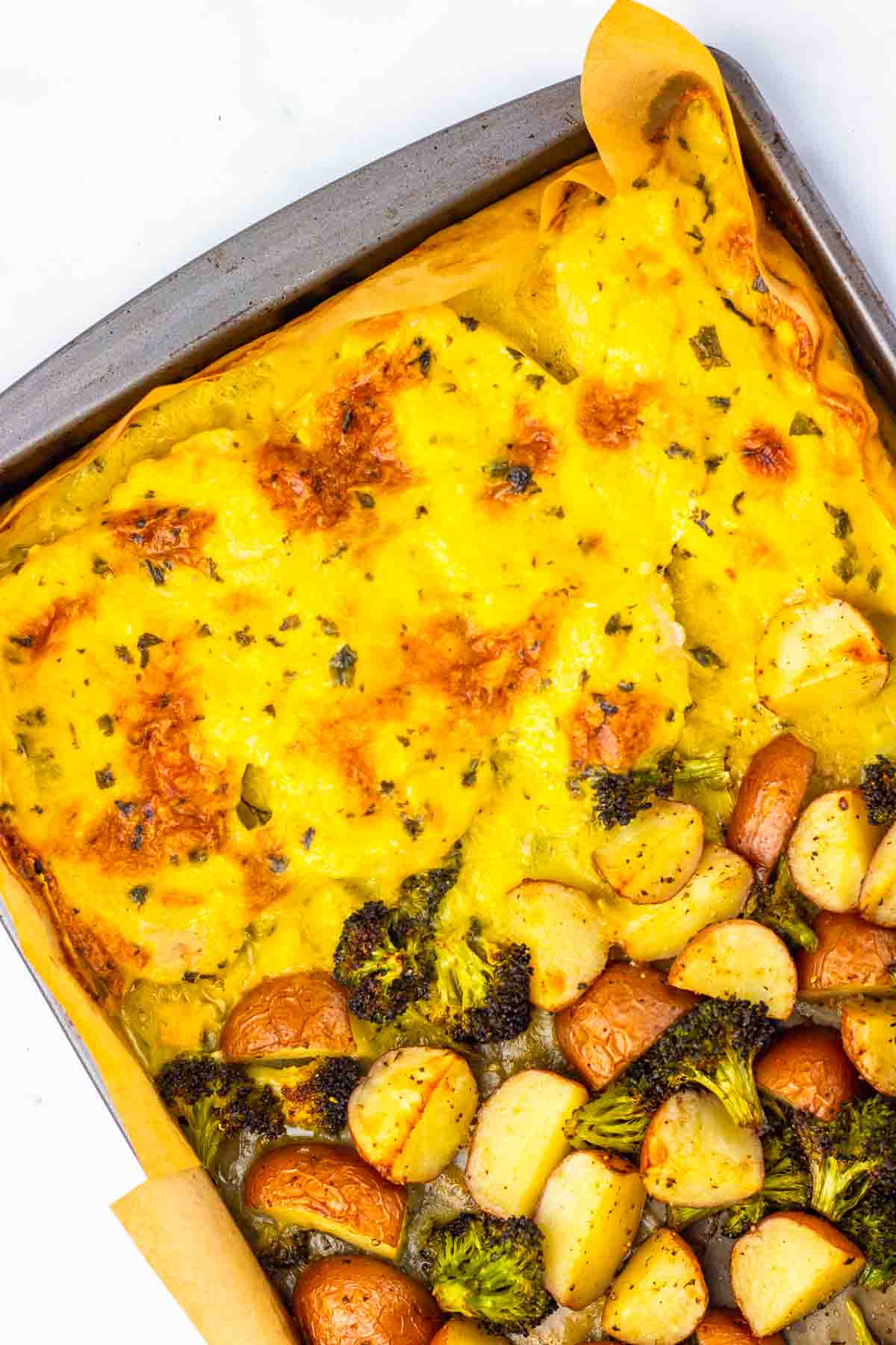 Sheet Pan Dinner featuring cheesy potatoes au gratin on one side and roasted potatoes with broccoli on the other&mdash;perfect alongside Parmesan Chicken or Creamy Chicken for a comforting meal.