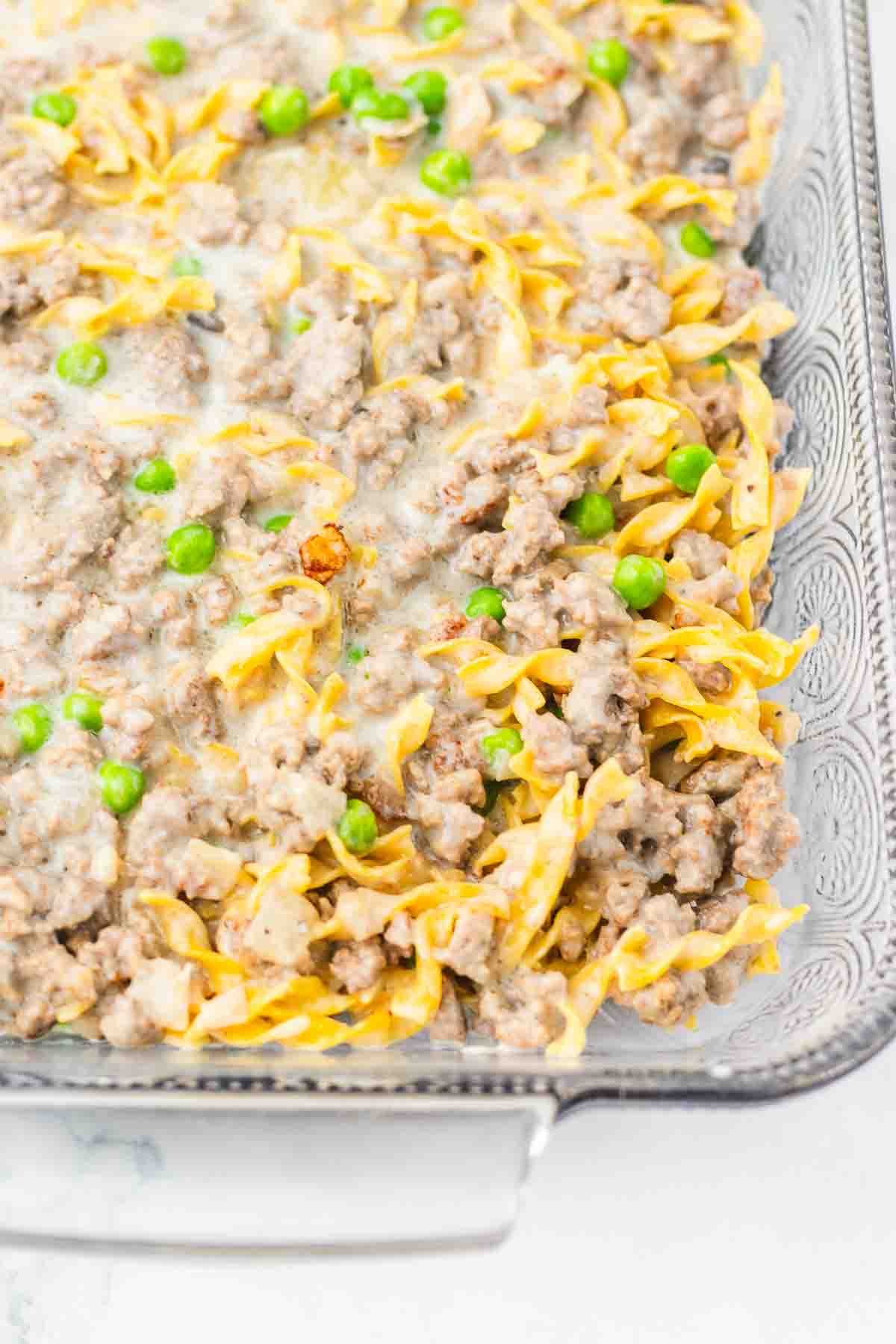 Casserole dish filled with creamy Amish Country Casserole, featuring tender noodles, ground meat, and green peas.