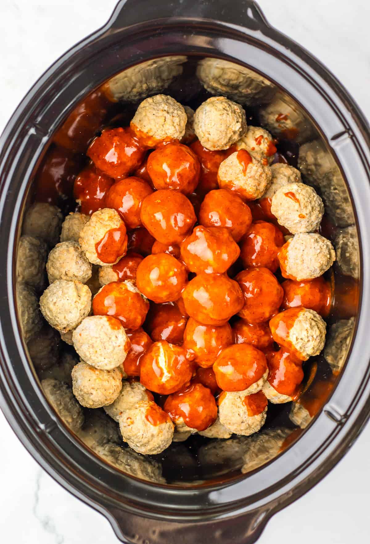 Slow Cooker Enchilada Meatballs&mdash;this 4 ingredient recipe features meatballs cooked in a slow cooker, with some covered in rich red enchilada sauce and others served plain for variety.