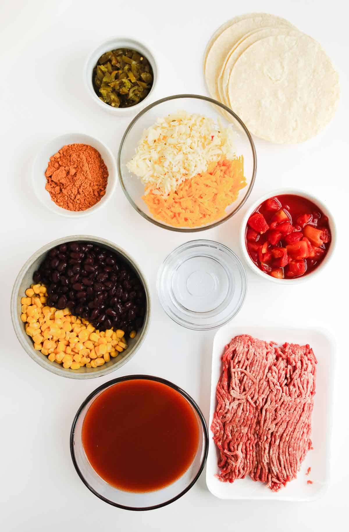 Taco ingredients: ground beef, tortillas, beans, corn, rice, cheese, tomatoes, sauce, seasoning, jalape&ntilde;os, water&mdash;perfect for a Beef Enchilada Casserole or your favorite taco casserole recipe.