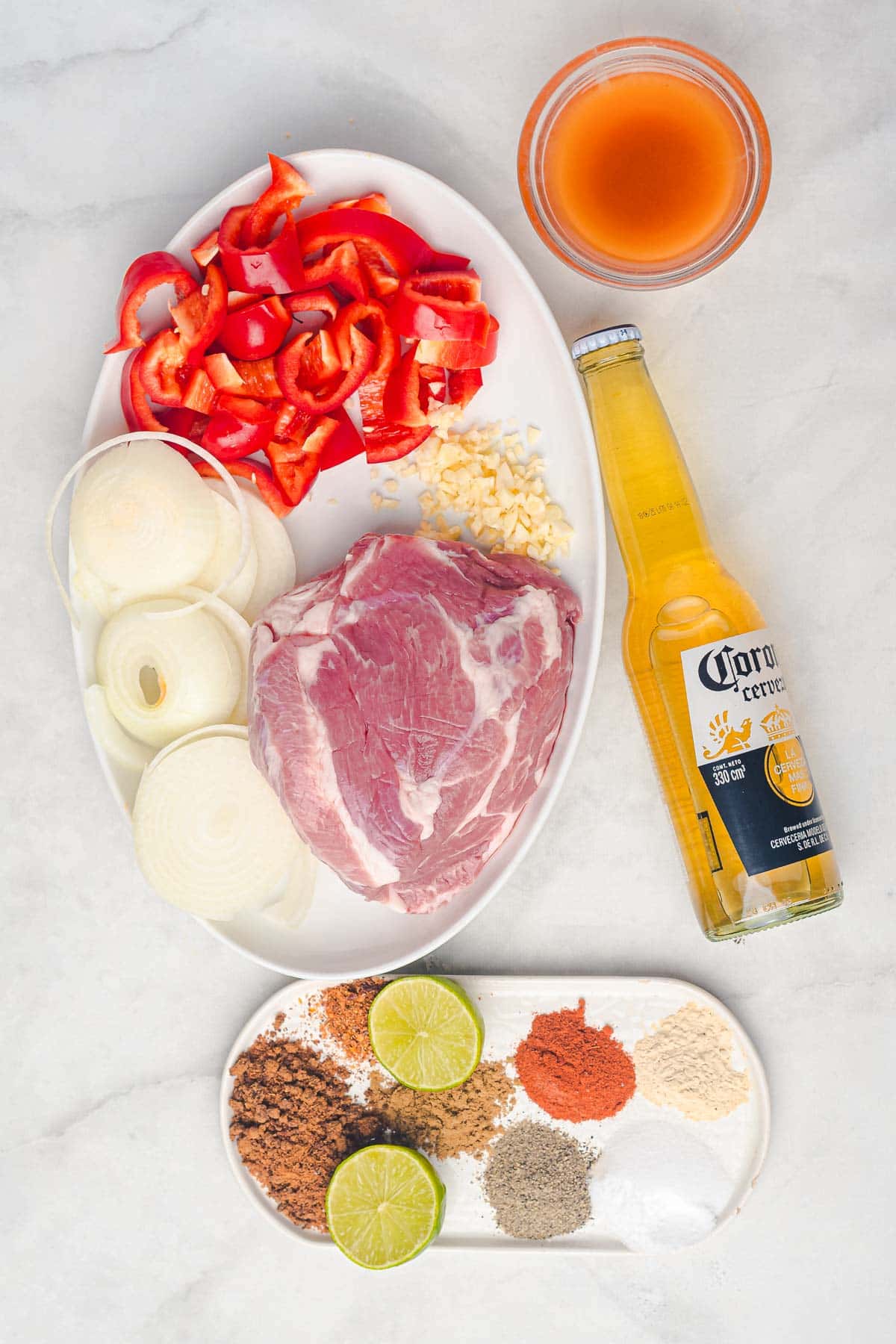 Raw pork, sliced onions, chopped red bell peppers, garlic, beer, apple cider vinegar, spices, and lime&mdash;perfect for making slow cooker Tex Mex pulled pork.