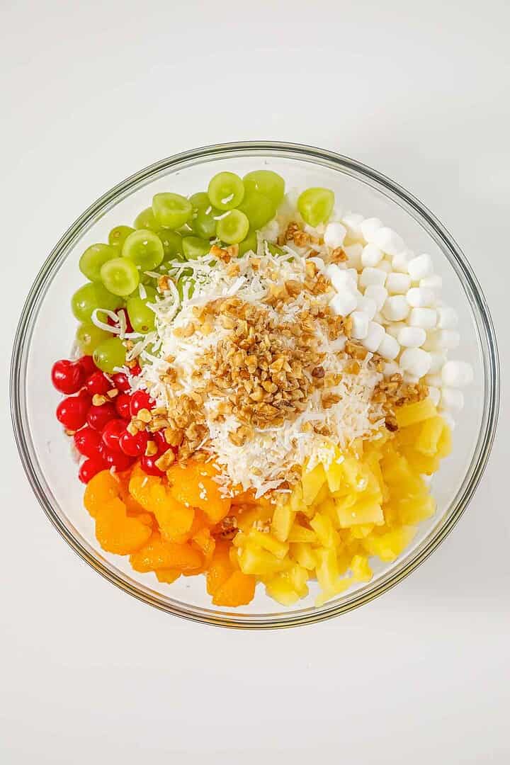 A glass bowl filled with colorful fruit, marshmallows, shredded coconut, and chopped nuts&mdash;this ambrosia recipe is a delightful fluff salad for any occasion.
