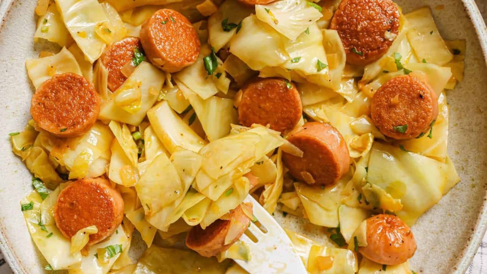 A pan of cabbage and sausage garnished with fresh herbs.