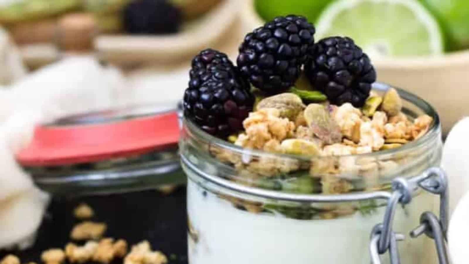 Overhead view of kiwi and blackberry on top of yogurt parfait.