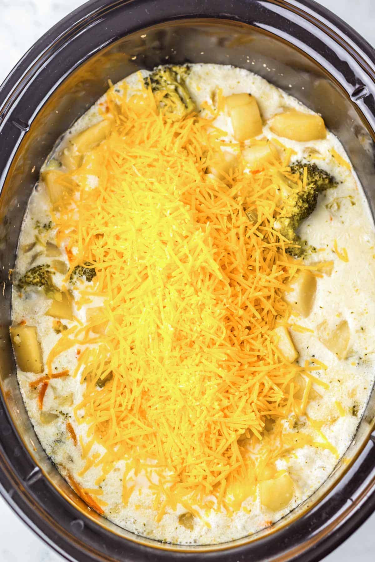 Cheesy Broccoli Soup with shredded cheddar tops a creamy broccoli and potato mixture, slowly cooked to perfection in your slow cooker.